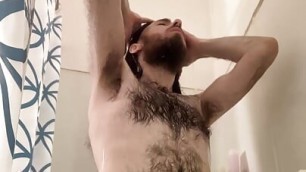 Very hairy white guy washes long dark hair in the shower, then scrubs dick, balls, and ass