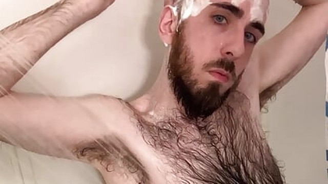 Very hairy skinny blue-eyed white guy shaves his head in the showet